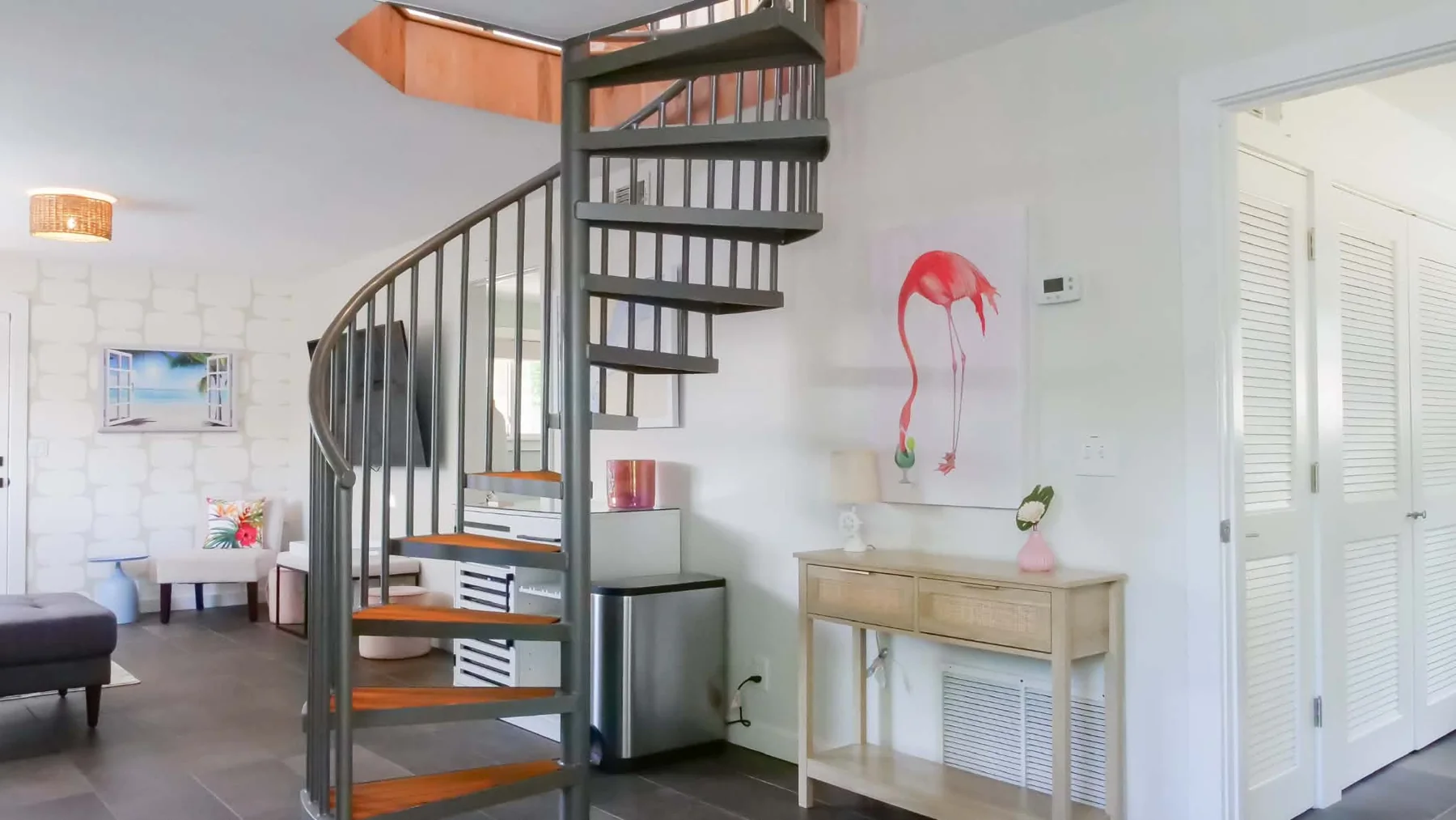 Spiral staircase beside flamingo artwork